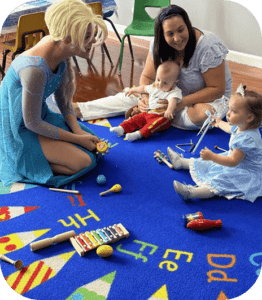 A group of people sitting on the floor playing with toys.