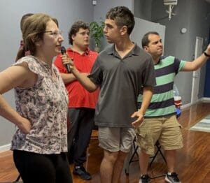 A group of people standing around in a room.
