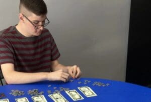 A boy is playing with money on the table