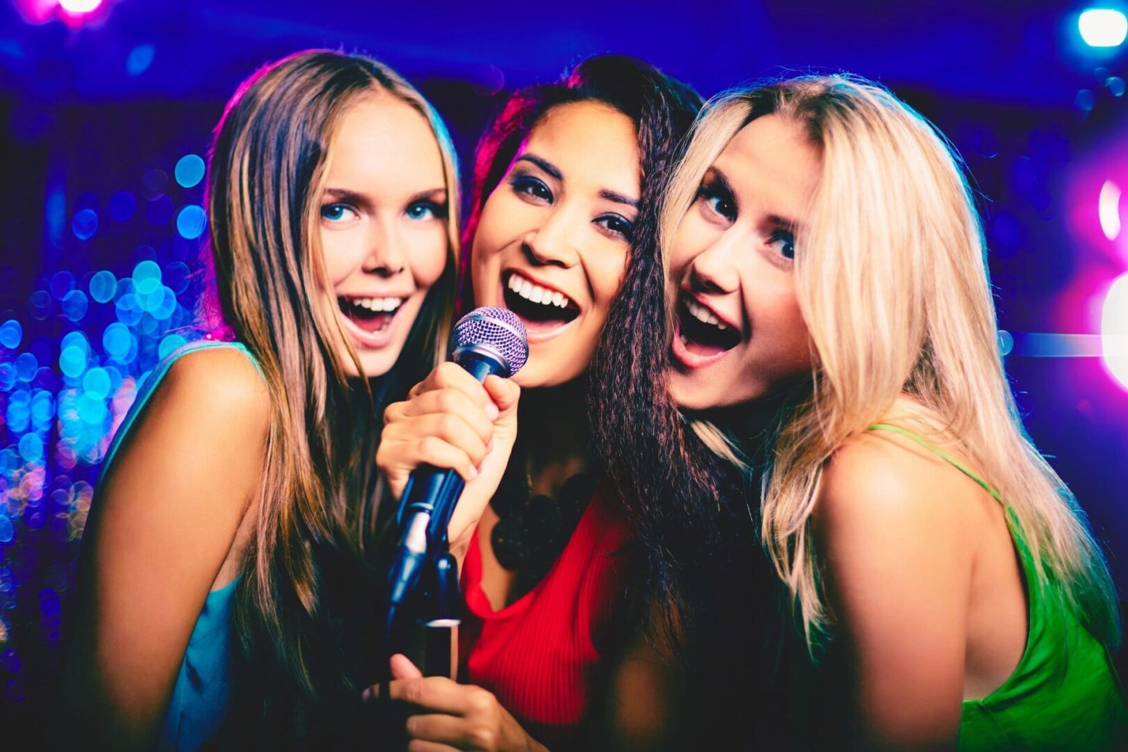 Three girls singing together on a song