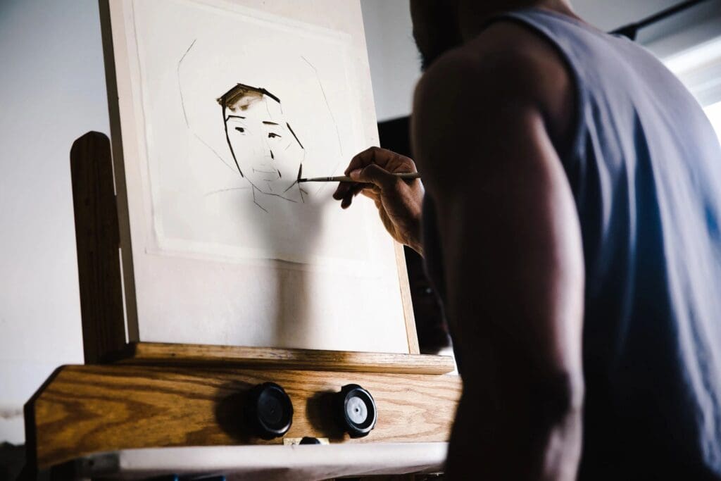 A man painting an image inside a house